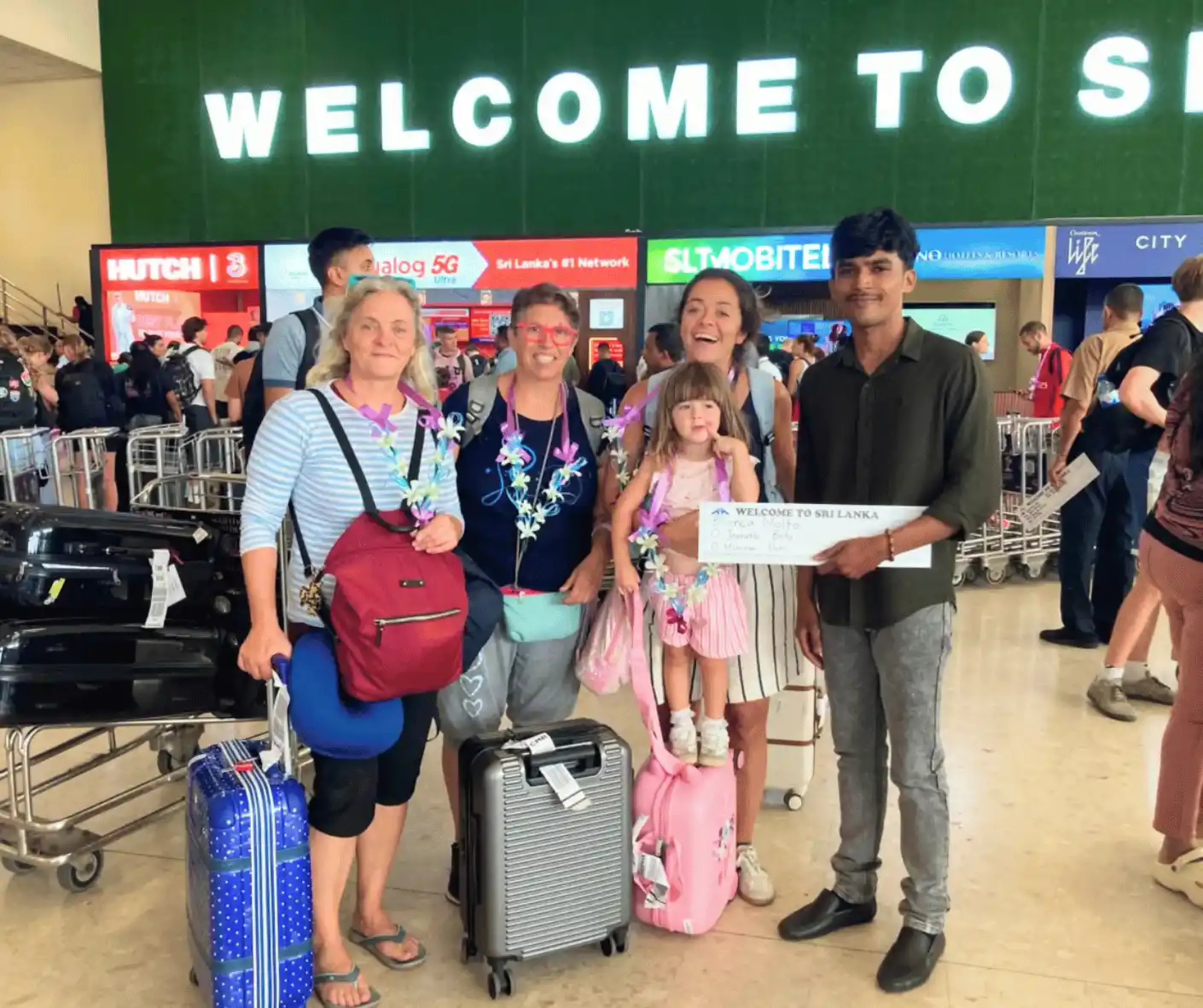 driver and guide welcoming a family from spain at the airport for their sri lankan tour and travel